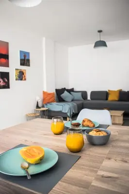 a wooden table with plates of food and orange juice at Seaside Inspire Wilderness in Quarteira