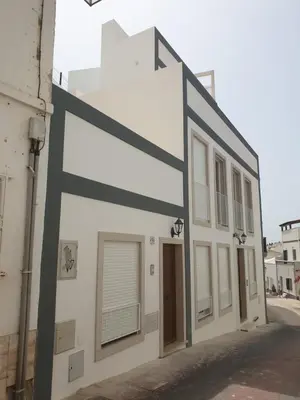 a building with a large sign on the side of it at Casa da Porta da Praia - 1 Bedroom Castle Wall Loft in Albufeira