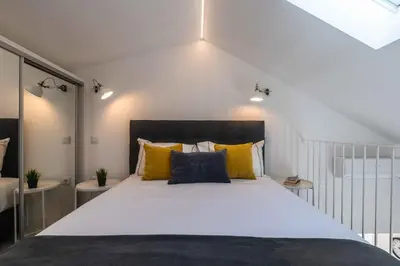 a bedroom with a large white bed with yellow pillows at Casa da Porta da Praia - 1 Bedroom Castle Wall Loft in Albufeira