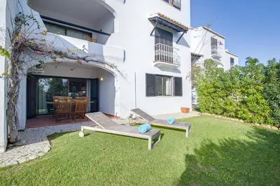 a yard with two benches and a house at Relaxing 2BD Apt 500m Beach w AC WiFi Pool in Albufeira
