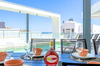 a bottle of wine sitting on a table with glasses at Villa Vista Albufeira Sea Views Heated Pool Walk To Marina in Albufeira