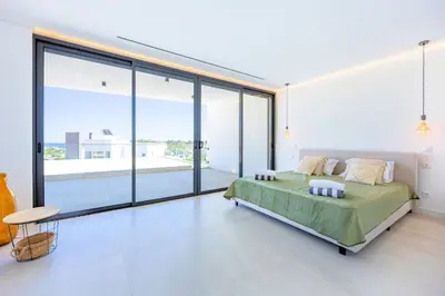 a bedroom with a bed and large glass windows at Villa Vista Albufeira Sea Views Heated Pool Walk To Marina in Albufeira