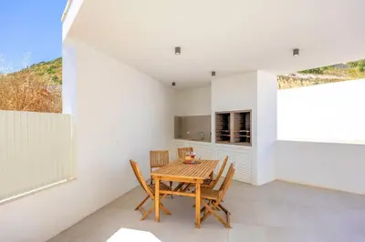 a dining room with a wooden table and chairs at Villa Vista Albufeira Sea Views Heated Pool Walk To Marina in Albufeira