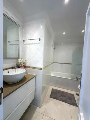 a white bathroom with a sink and a tub at Vilamoura View Apartment in Quarteira