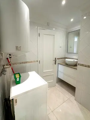 a white bathroom with a white sink and a toilet at Vilamoura View Apartment in Quarteira