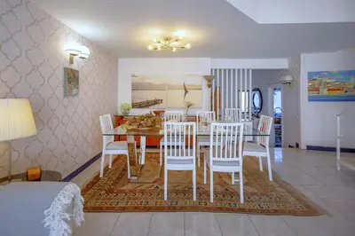 a dining room and living room with a table and chairs at Villa Lina - Vilamoura in Quarteira