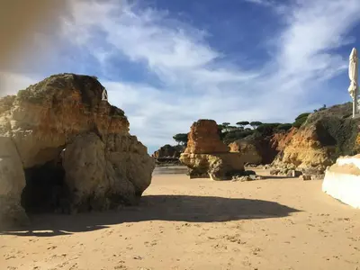 a sandy beach with large rocks on a beach at Beautiful T2 Apartamento Olhos do Mar in Olhos de Água