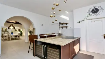 a kitchen with a counter and a dining room at Villa Albatros Cleverdetails, Vilamoura, private pool and jacuzzi in Vilamoura