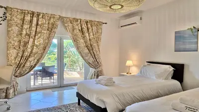 a bedroom with two beds and a sliding glass door at Villa Albatros Cleverdetails, Vilamoura, private pool and jacuzzi in Vilamoura