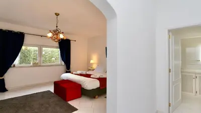a bedroom with a bed and a red stool at Villa Albatros Cleverdetails, Vilamoura, private pool and jacuzzi in Vilamoura