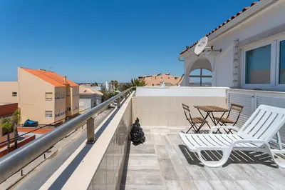 a balcony with two white chairs and a table at Blife Charlya private rooms at Faro beach in FAO