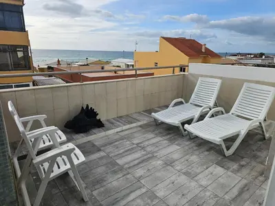 two chairs and two stools on a balcony with the ocean at Blife Charlya private rooms at Faro beach in FAO