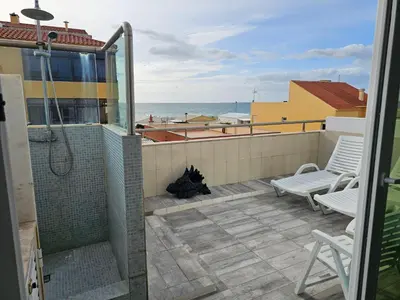 a balcony with a shower and a cat laying on avisor at Blife Charlya private rooms at Faro beach in FAO