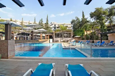 a pool at a hotel with blue lounge chairs at Studio 54 by Sunnyway in Albufeira