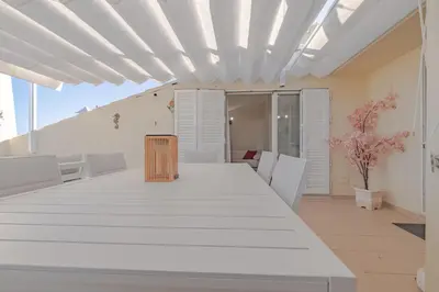 a dining room with a white table and chairs at Rooftop with sea views by Algarve Dream Holidays in Albufeira