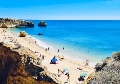 a group of people on a beach near the ocean at Rooftop with sea views by Algarve Dream Holidays in Albufeira