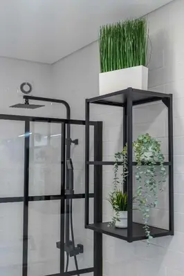 a black shelf with potted plants on it at Casa da Porta da Praia - 3 Bedroom Castle Wall House in Albufeira