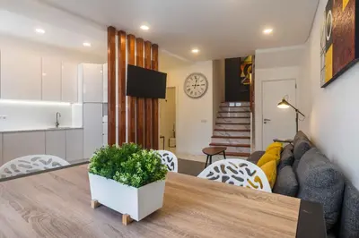 a kitchen and living room with a table and a couch at Casa da Porta da Praia - 3 Bedroom Castle Wall House in Albufeira