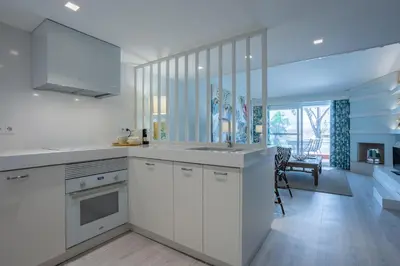 a kitchen with white cabinets and a sink at The Palm Nest