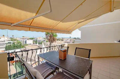 a balcony with a table and chairs and an umbrella at Condo-Pool walk to the Beach by Algarve Dream Holidays in Albufeira