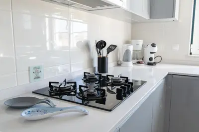 a white kitchen with a stove top oven at Condo-Pool walk to the Beach by Algarve Dream Holidays in Albufeira