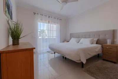 a bedroom with a large bed and a window at Condo-Pool walk to the Beach by Algarve Dream Holidays in Albufeira