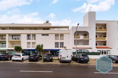 a large white building with cars parked in front of it at Albufeira Breeze Living - Dream Lodging in Albufeira
