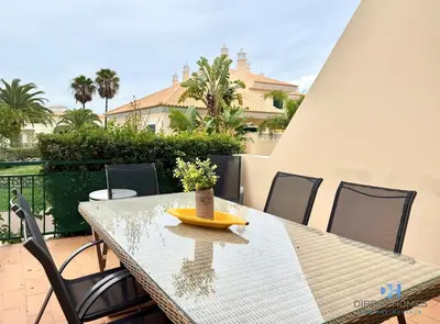 a living room with a table and a tv on the wall at Villa Rosal 21 in Albufeira
