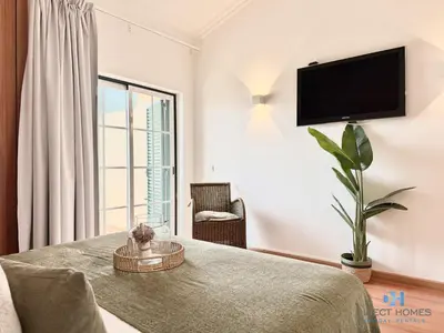 a living room with two beds and a staircase at Villa Rosal 21 in Albufeira
