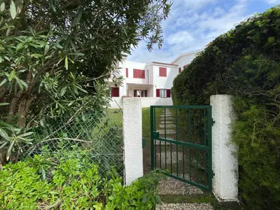 a gate in a fence in front of a house at Casa Manacá Vilamoura in Quarteira