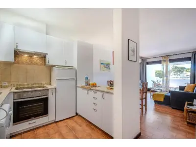 a kitchen with white cabinets and a counter with fruit on it at Apartment Ivone - Sunny Way by Interhome in Albufeira
