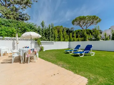 a patio with chairs and a table and an umbrella at Villa Amélia - Sunny Way by Interhome in Albufeira