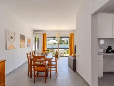 a kitchen with white cabinets and a bowl of fruit on the counter at Villa Amélia - Sunny Way by Interhome in Albufeira
