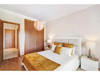 a bedroom with a white bed and a chandelier at Apartment Loft 39 - Sunny Way by Interhome in Albufeira