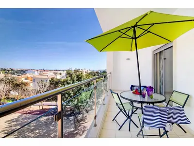 a balcony with a table and a yellow umbrella at Apartment Loft 39 - Sunny Way by Interhome in Albufeira