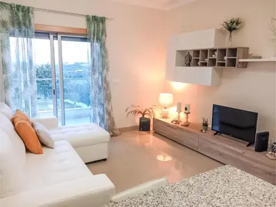 a living room with a white couch and a television at Apartment Loft 39 - Sunny Way by Interhome in Albufeira