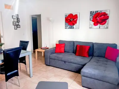 a living room with a blue couch and red pillows at Apartment Manelito House - Sunny Way by Interhome in Albufeira