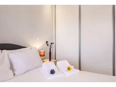 a bedroom with a bed with white pillows and flowers on it at Apartment Max Tropical - Sunny Way by Interhome in Albufeira