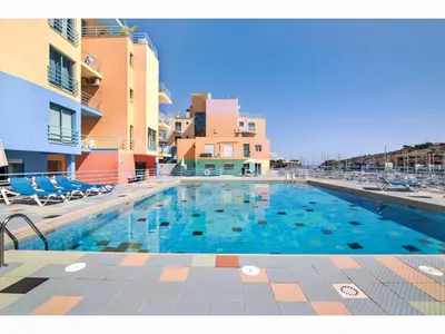 a large swimming pool with chairs and some buildings at Apartment W Marina - Sunny Way by Interhome in Albufeira