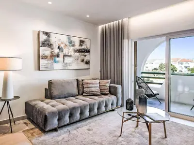 a living room with a couch and a large window at Apartment Albufeira Prestige - Sunny Way by Interhome in Albufeira