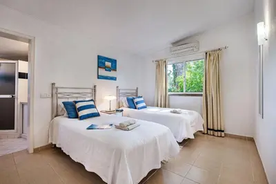 a bedroom with a large bed and a white cabinet at 4 Beds, Golf Views, optional pool heating in Vilamoura