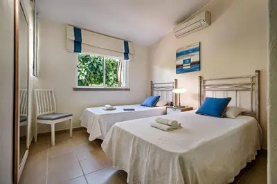 two beds in a white room with a window at 4 Beds, Golf Views, optional pool heating in Vilamoura