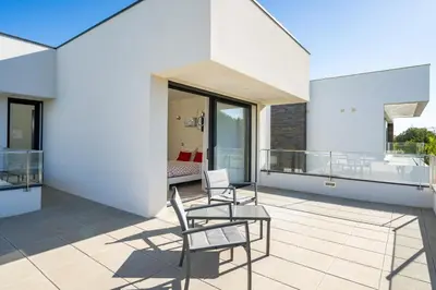 a balcony with chairs and a table on a building at Vitoria 7th hole by SAPvillas in Vilamoura