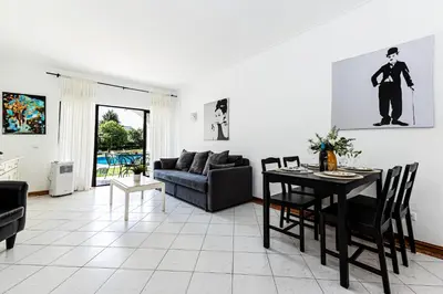 a living room with a table and a couch at Ground floor with direct access to swimming pool in Albufeira
