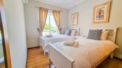 two beds in a room with a window at Golfview Apartment in Quarteira