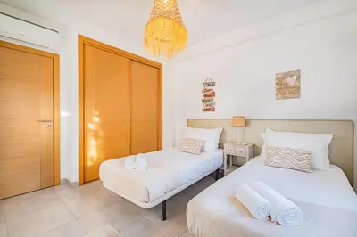a bedroom with two beds and a chandelier at Vitismar Praia Algarve in Guia