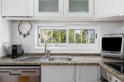 a kitchen with a sink and a window at Bright 3BDR Vilamoura Retreat Flat by LovelyStay in Quarteira