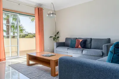 a living room with a couch and a coffee table at Palm Breeze Retreat in Albufeira w Pool and Balcony by Lisbeyond in Albufeira