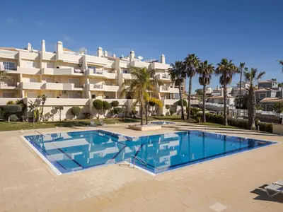 a swimming pool in front of a large building at Palm Breeze Retreat in Albufeira w Pool and Balcony by Lisbeyond in Albufeira