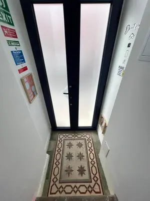 a hallway with a door and a tile floor at Dolce Faro Niente Guest House in Faro